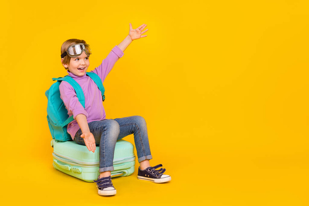 Photo of funny good mood casual wear boy kid prepare to travel go on adventure isolated on yellow color background - Foto, Imagen