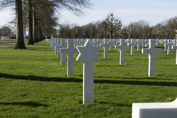 Netherlands,Limburg,Margraten, february 12 2022: Rows of Memorial crosses and David star tombstones at the American Cemetery and Memorial - Foto, afbeelding