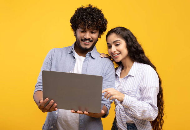 Éducation en ligne, travail à distance et achats. Couple indien heureux regardant ordinateur portable, choisir l'achat ou regarder la leçon - Photo, image