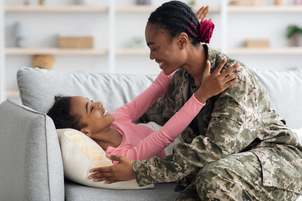 Γυναίκα στρατιώτης ξύπνησε το παιδί της, γύρισε σπίτι. - Φωτογραφία, εικόνα