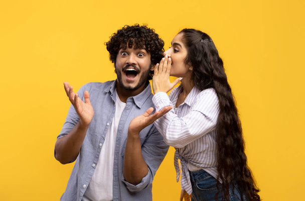 Jeune femme indienne partageant des secrets avec son petit ami excité, couple millénaire chuchotant potins les uns aux autres - Photo, image