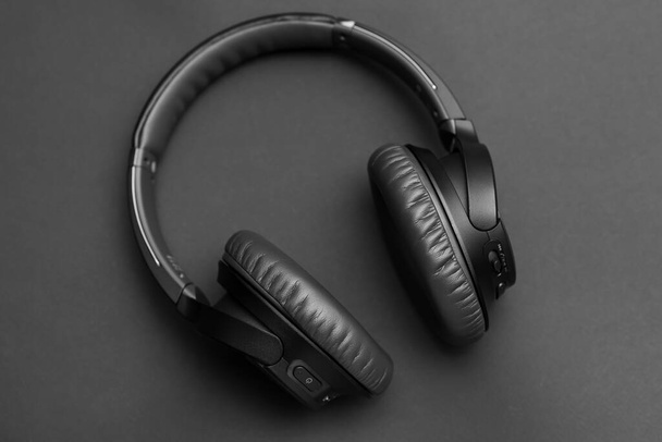 auriculares inalámbricos negros sobre fondo negro
 - Foto, Imagen