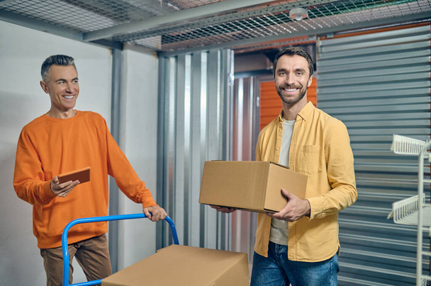 Two warehouse workers standing in the storage room - Foto, Imagen