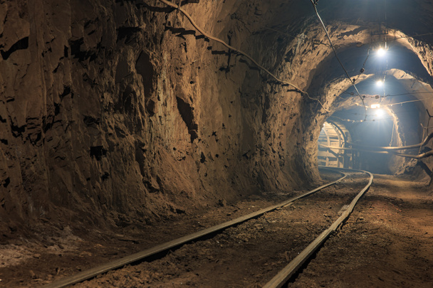 Ferrocarril de ancho estrecho en el horizonte de la mina subterránea. Tecnologías de minería de minerales por el método subterráneo. Mina subterránea para mineral minero - Foto, imagen
