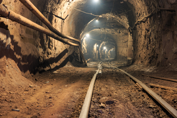 Narrow gauge railroad in the underground mine horizon. Technologies of mining of minerals by the underground method. Underground mine for mining ore - Photo, Image