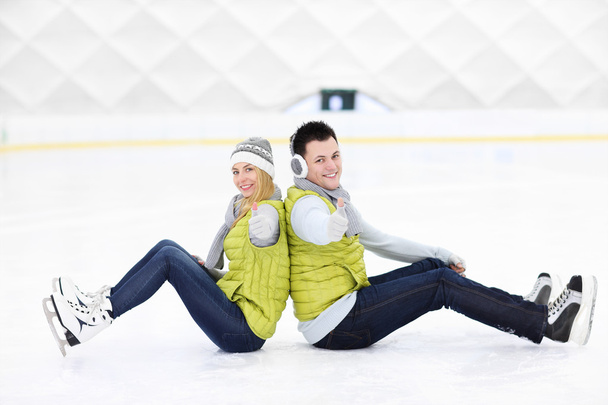 Cheerful couple sitting on the skating rink - Foto, Imagem
