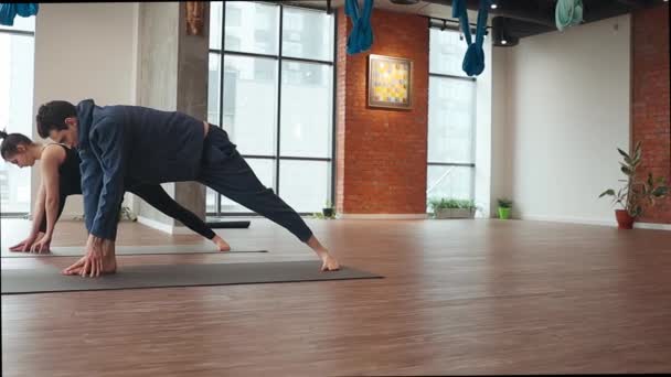 Чоловік і жінка практикують синхронні вправи на підлозі мат в студії йоги
 - Кадри, відео