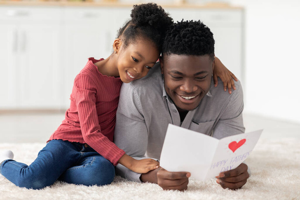 Sevgi dolu küçük siyah kız Babalar Günü 'nde babasını selamlıyor. - Fotoğraf, Görsel