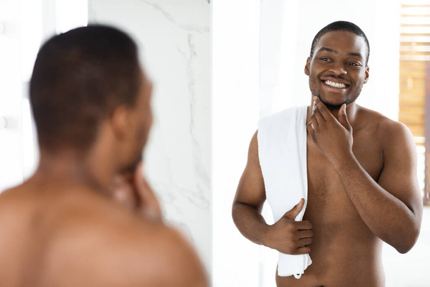 Self Care Concept. Shirtless Black bel homme regardant miroir dans la salle de bain - Photo, image