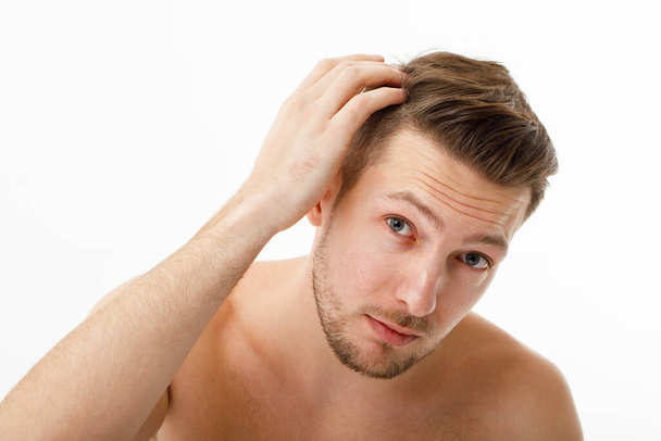 The young man was upset when he noticed his gray hair. Hair care, baldness graying. - Photo, Image