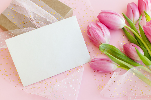 Empty greeting card, pink tulips bouquet and gift box on pink background. Greeting card template with space for text. Happy womens day. 8 march. Happy Mothers day - Photo, Image