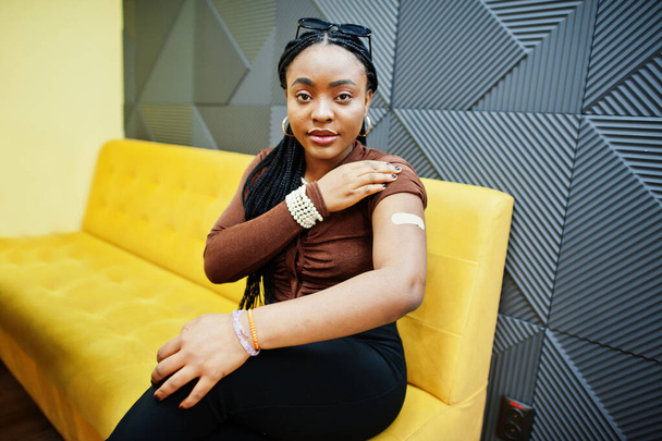 Stay safe! Black woman showing vaccinated arm after vaccine injection.  - Foto, Imagen