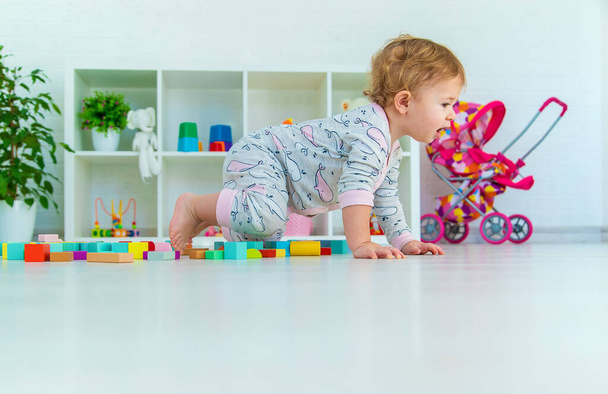 Bir bebek çocuk oyun odasında oyuncaklarla oynar. Seçici odaklanma. Çocuk. - Fotoğraf, Görsel