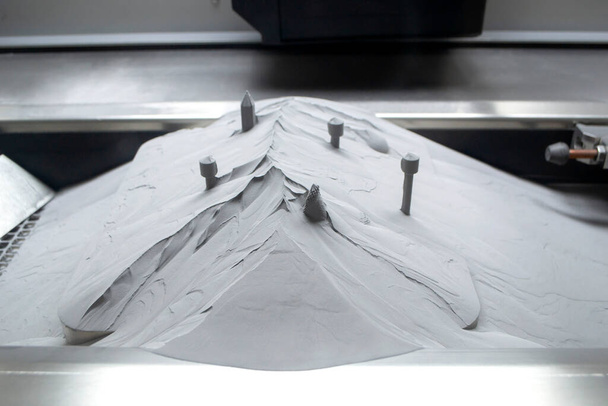 Поверхня з друкованими об'єктами на металевому 3D принтері, покрита металевим порошком
 - Фото, зображення