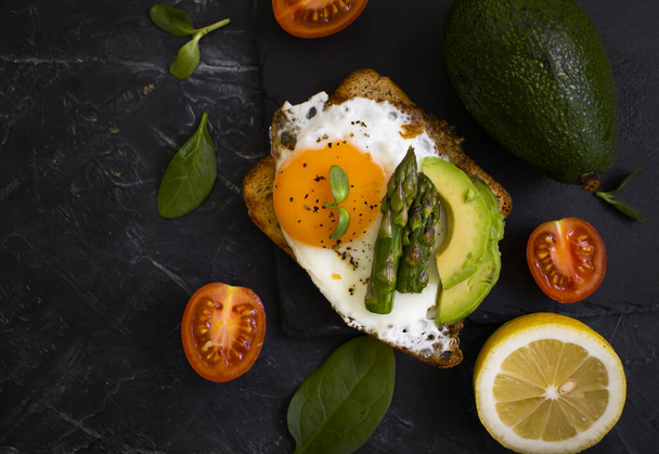 сэндвич с яйцом, авокадо, спаржа на старом фоне - Фото, изображение