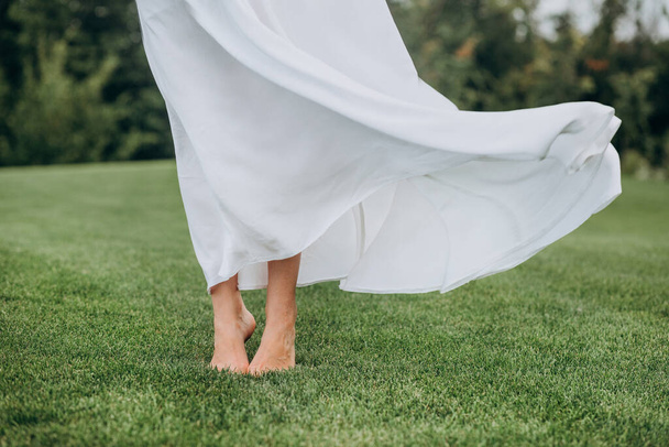 bare feet bride on soft green lawn light movemen - Fotoğraf, Görsel