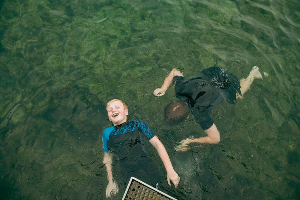 Top pohled na děti plavající v průzračné modré vodě v Bogey Hole v Newcastlu, Nový Jižní Wales Austrálie - Fotografie, Obrázek