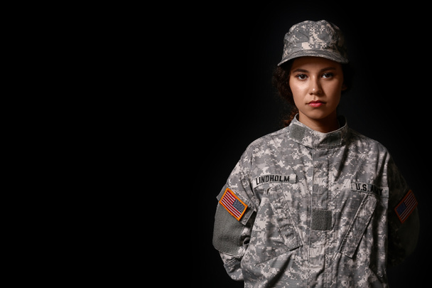 Afro-Amerikaanse vrouwelijke soldaat op donkere achtergrond - Foto, afbeelding