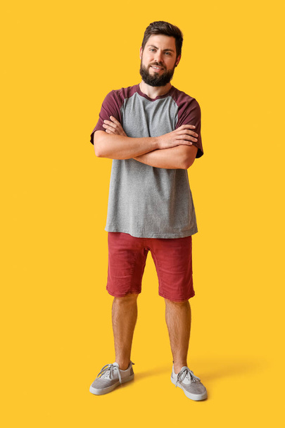 Handsome man in t-shirt on yellow background - Foto, imagen