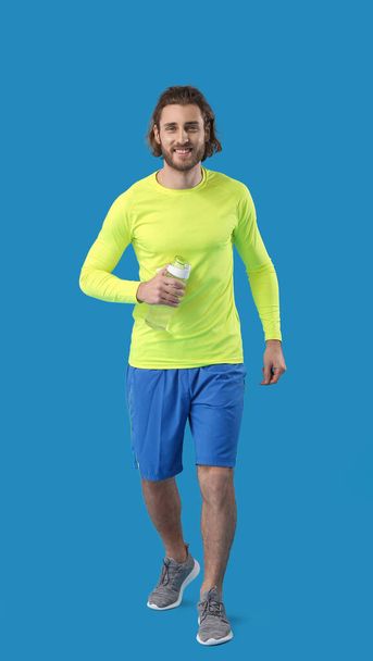 Sportos férfi üveg víz kék háttér - Fotó, kép