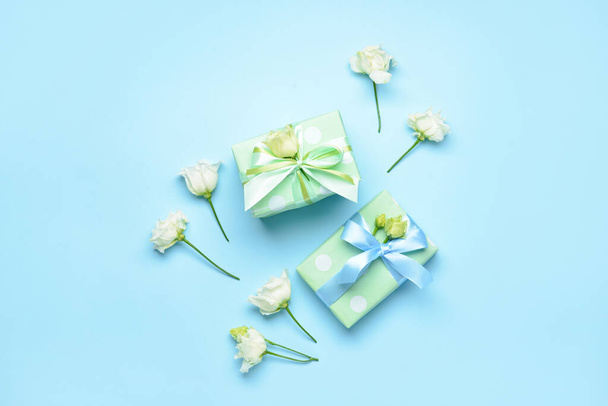 Composición con cajas de regalo y flores de eustoma sobre fondo de color. Celebración del Día Internacional de la Mujer - Foto, Imagen
