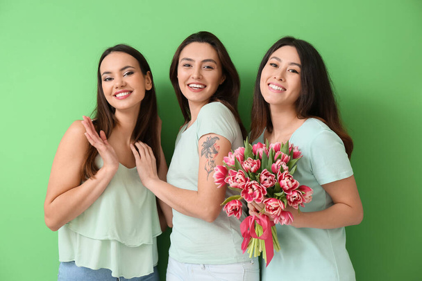 Schöne Frauen mit Blumen auf grünem Hintergrund. Feier zum Internationalen Frauentag - Foto, Bild
