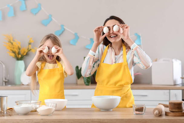 Маленька дівчинка з матір'ю розважається, готуючи пиріг на кухні
 - Фото, зображення