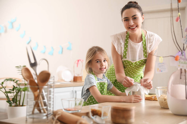 Petite fille avec sa mère préparant le gâteau de Pâques dans la cuisine - Photo, image