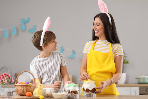 Niño y su madre decorando pasteles de Pascua en la cocina - Foto, Imagen