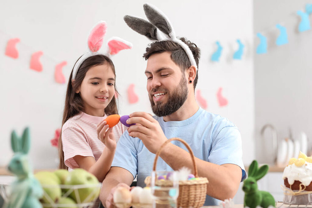 Kislány az apjával húsvéti tojásokat törnek fel a konyhában. - Fotó, kép