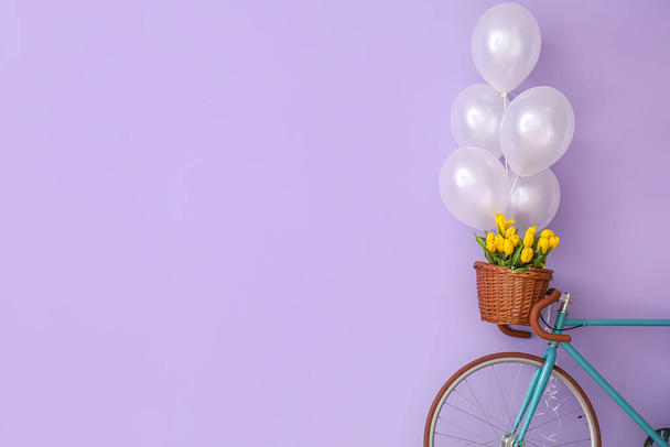 Fahrrad, Korb mit Tulpen und Luftballons in der Nähe der Wand - Foto, Bild