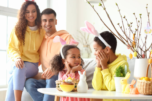 Joyeux petits enfants avec leurs parents à la maison le jour de Pâques - Photo, image