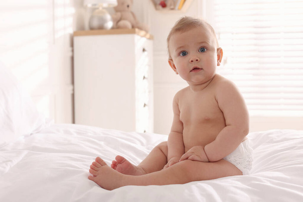 Cute little baby on bed at home. Space for text - Foto, immagini