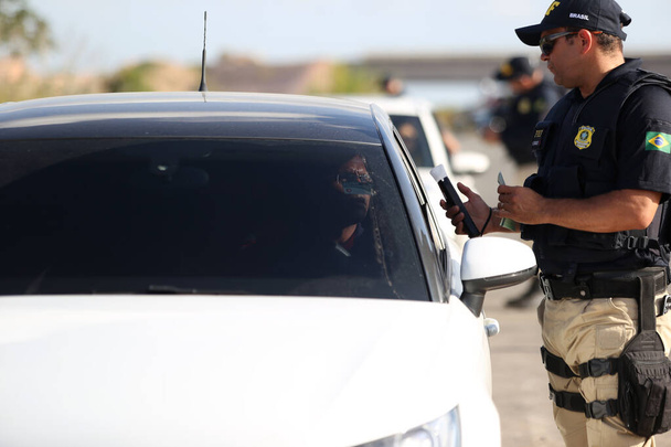 simoes filho, bahia, brazil - october 11, 2018: Agent of the Federal Highway Police - PRF - inspects a driver on federal highway BR 324 in the city of Simoes Filho. - 写真・画像
