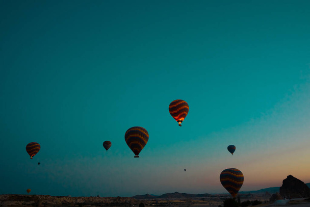 Cappadocia balloons. Hot air balloons in Goreme at sunrise. Travel to Turkey background photo. Noise included. - Foto, Bild