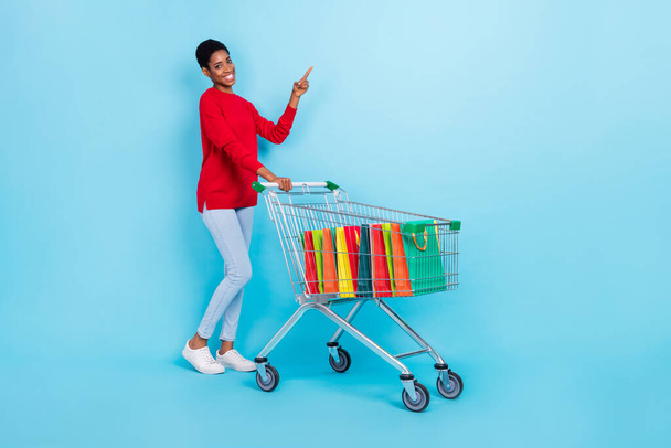 Full size photo of androgynous appearance trans lesbian girl go shopping advertise bargains isolated on blue color background - Photo, Image
