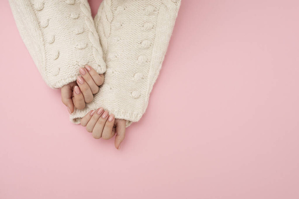 woman in sweater showing her nails with manicure - Foto, Imagem
