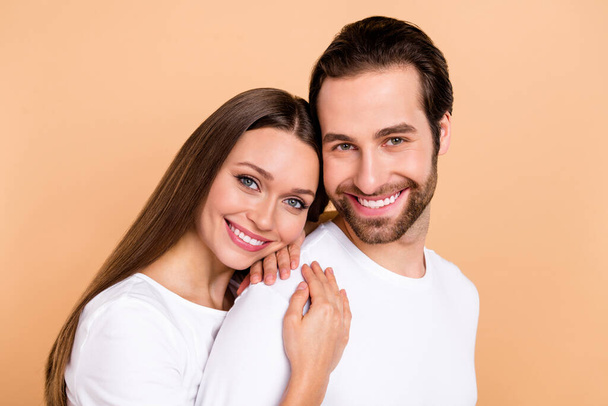Photo of lovely millennial brown hairdo couple hug wear white cloth isolated on beige color background - Fotografie, Obrázek