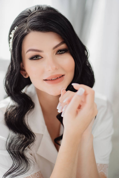 the face of a beautiful brunette bride with long hair and a white hairpin.  - Фото, зображення