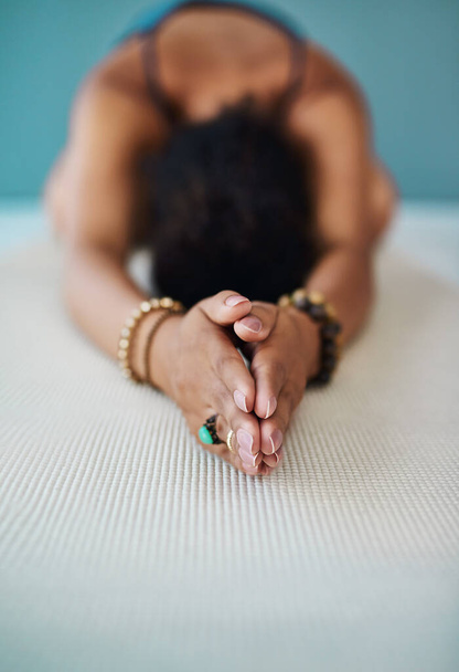 Working her way through the various positions. Shot of a young woman practising yoga. - Foto, immagini
