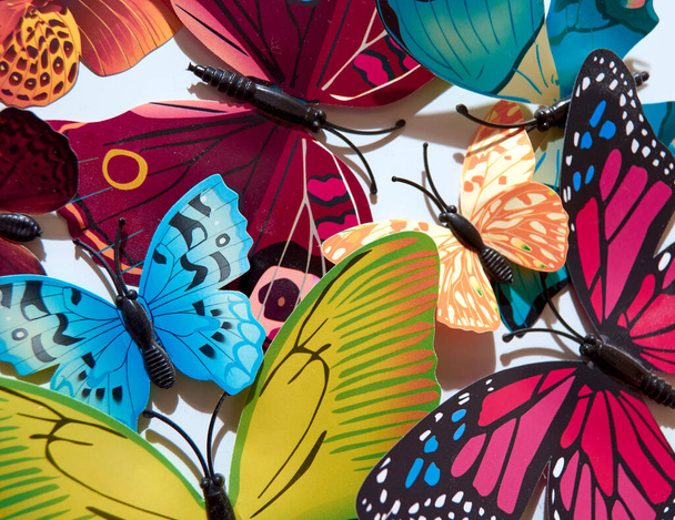 Kunststoff farbige künstliche Schmetterlinge auf weißem Hintergrund - Foto, Bild