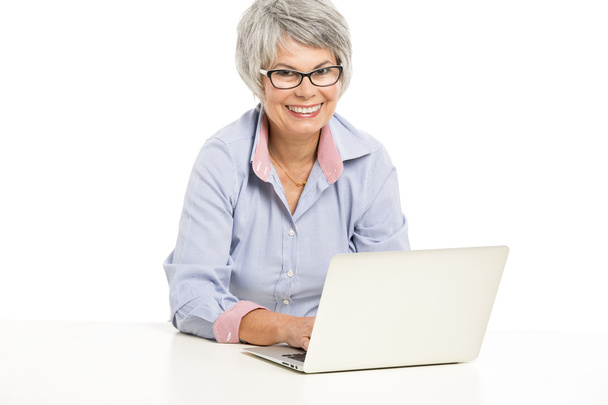 Ellderly woman working with a laptop - Photo, Image