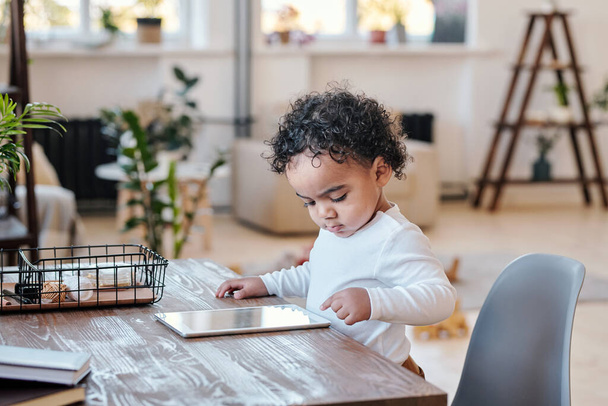 Bambino moderno che utilizza tablet a tavola - Foto, immagini