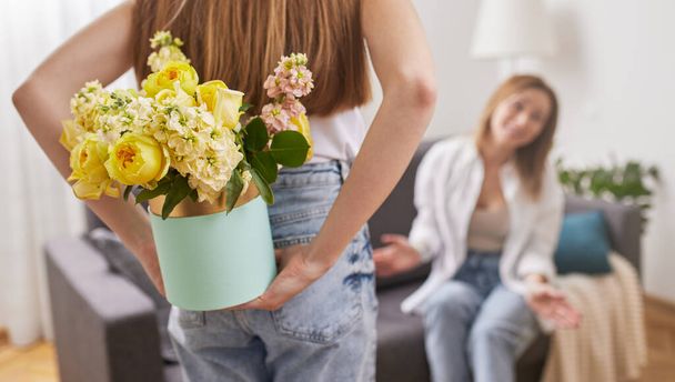 Daughter with flowers in box for mother - Фото, зображення