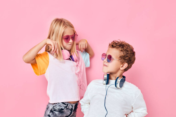 adorable little kids entertainment headphones playing pink color background - Foto, imagen