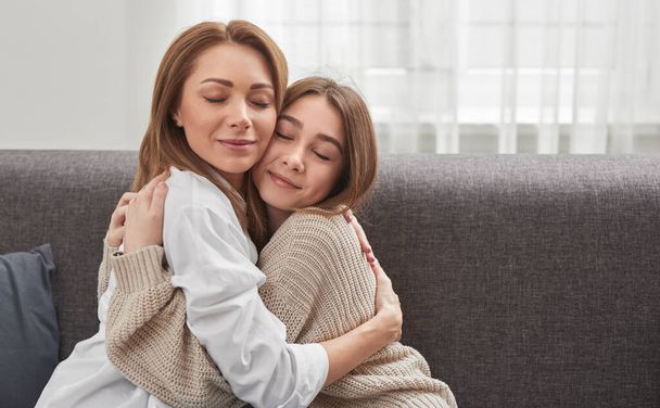 Content mother and daughter hugging at home - Φωτογραφία, εικόνα