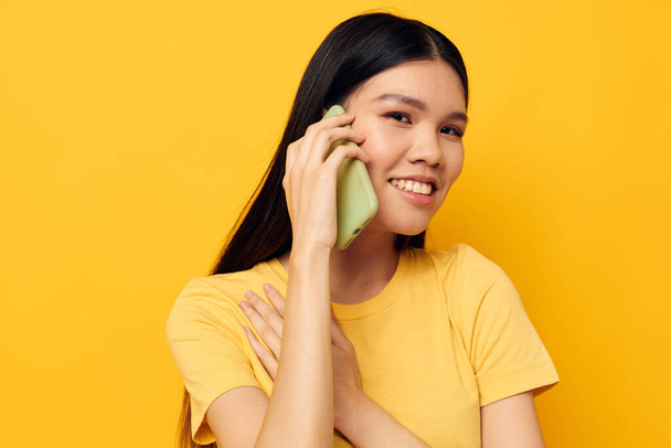 Portrait Asian beautiful young woman talking on the phone posing technology studio model unaltered - Фото, изображение