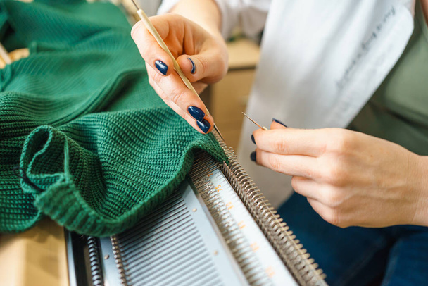 la persona è impegnata in lavorare a maglia su una macchina per maglieria familiare. fatto a mano - Foto, immagini