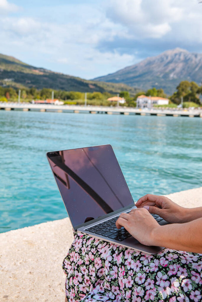 mulher sorridente freelancer trabalhando no laptop ao ar livre no espaço cópia porto da cidade - Foto, Imagem