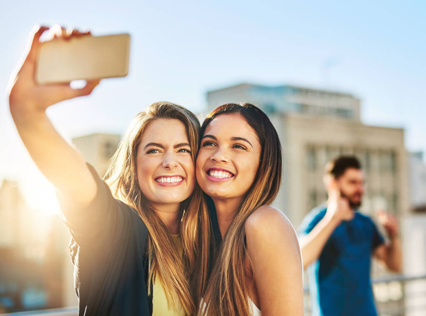 Say cheese. Shot of young female friends taking a selfie outside. - Foto, Bild